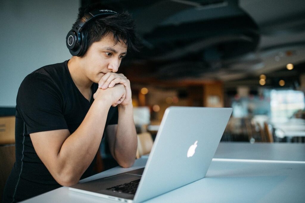 Konzentrierter Mann mit Kopfhörern vor dem Computer